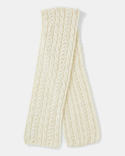 A cream-colored knitted unisex-scarf crafted from Heritage Worsted Wool, featuring a textured pattern with alternating cable and ribbed designs. The scarf is neatly folded, displaying its intricate detailing and soft, cozy material. The plain white background highlights the scarf's craftsmanship. This is the Aran Irish Knit Cable Scarf - B386 from Mjölkshop.se.