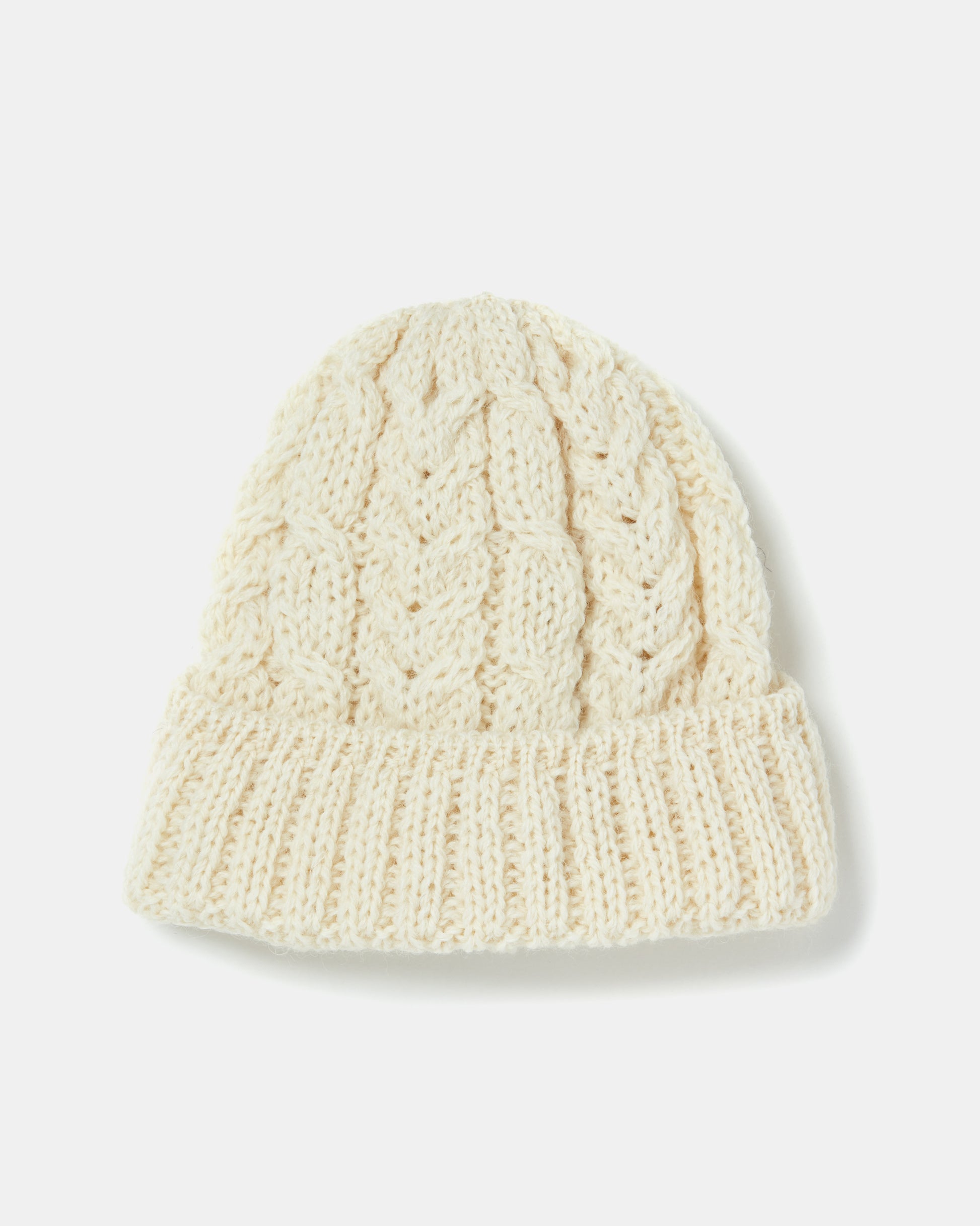 A cream-colored, knitted beanie, reminiscent of a classic Aran-hatt with a thick ribbed cuff and cable-knit pattern, lies on a white background. It is the Aran Irish Knit Cable Hat - B387 by Mjölkshop.se.