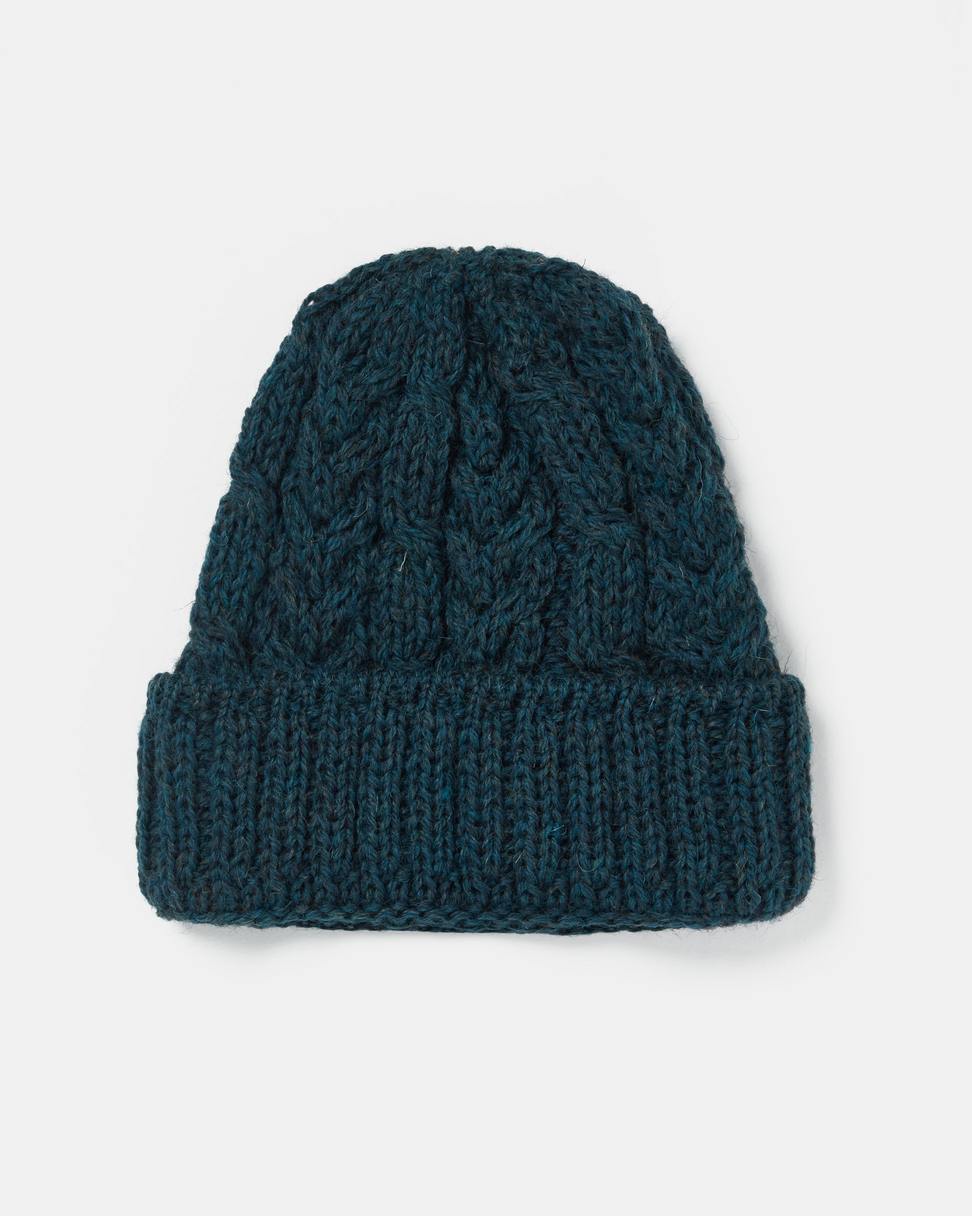 A dark teal, knitted beanie with a ribbed fold-over cuff and a cable-knit pattern on the body. This stylish Aran Irish Knit Cable Hat - B387, a true heritage ull creation by Mjölkshop.se, is presented against a plain white background.